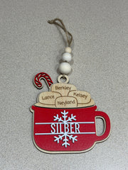 Decorative ornament with red mug and wooden name tags on a gray background