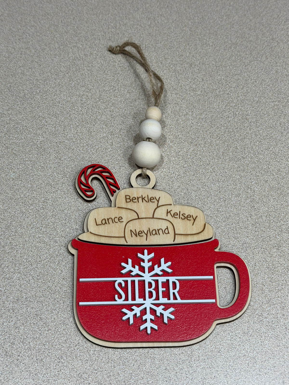 Decorative ornament with red mug and wooden name tags on a gray background